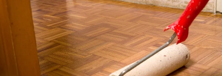 Parkettboden wird mit Rolle lackiert